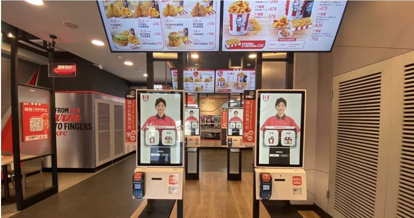 在KFC數位未來店2.0全新升級的數位迎賓櫃檯，可見AI實習店員卡拉以親切友善的態度介紹人氣餐點。