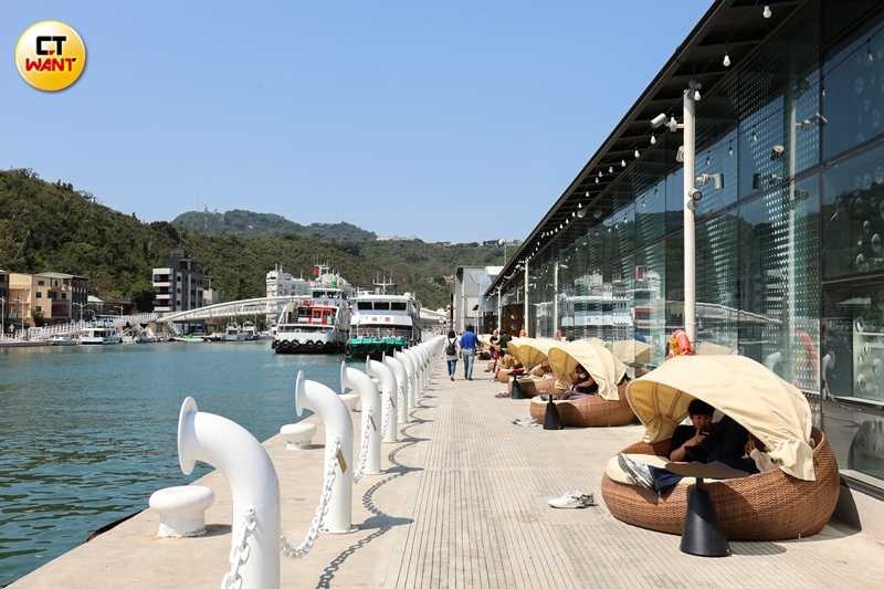 在新濱町海洋廚房戶外區域有類似營帳型態的座位區,與圖中情侶最愛的港邊賞景座位,黃昏時尤為搶手。(圖/林士傑攝)