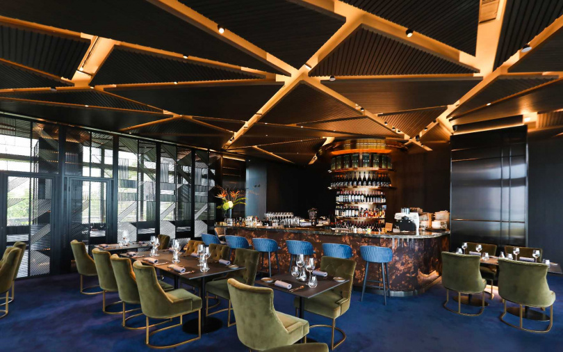室內用餐區以深色調做為主要設計，室內、外共設置95席座位。（圖／PANO提供）