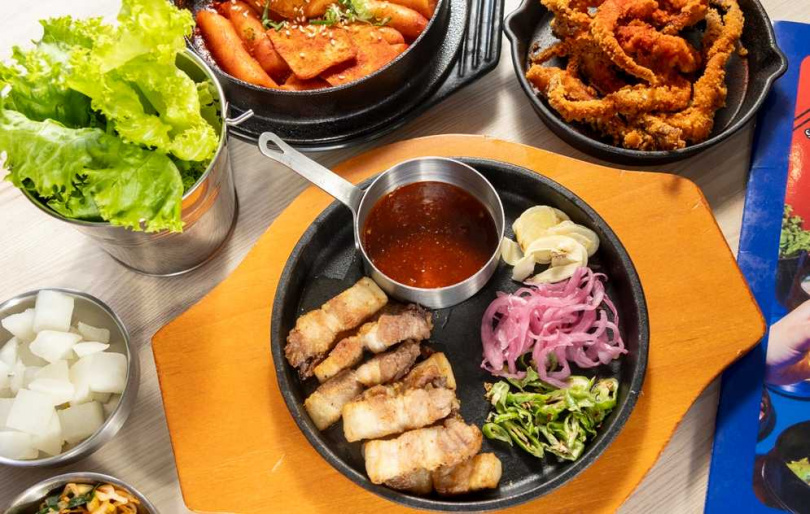 附上生菜可以包肉吃的「厚切豬五花」（中，258元）、「酥炸魷魚」（後右，加購88元、單點138元）、「辣炒年糕」（98元）都是人氣菜色。（圖／楊澍攝）