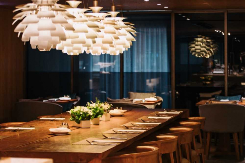 GUSTOSO義大利餐廳採用低調沉穩的色調搭配高質感原木色傢俱，窗外緊鄰敦南綠蔭景色，營造舒適的用餐空間。