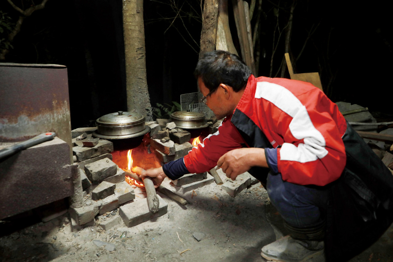 在戶外爐灶以柴燒炊熟米飯，是「巴庫拉斯生態農莊」的日常生活趣味。（圖／于魯光攝）