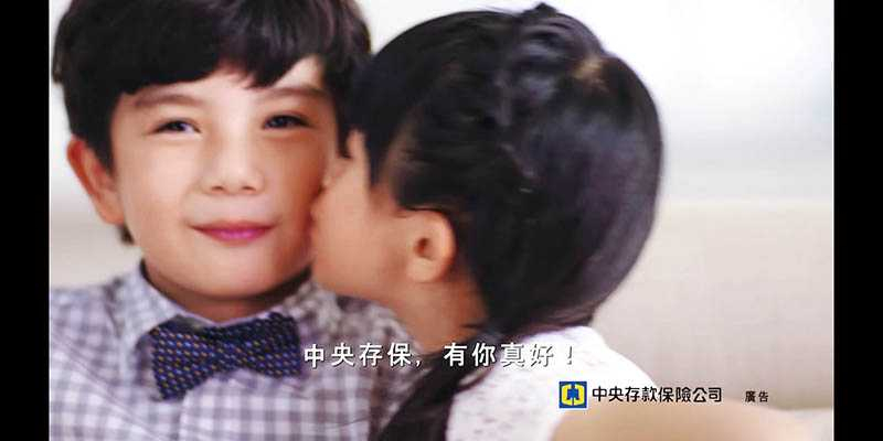 小二時吳以涵與另一名童星拍攝「中央存保」廣告，親親這一幕讓不少男同學吃醋。（圖／翻攝自YOUTUBE）
