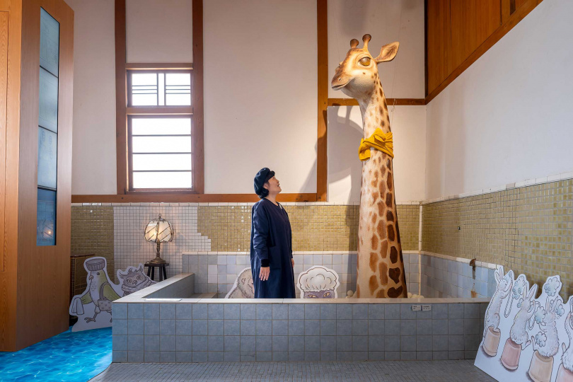 遊客可走進男浴池和長頸鹿來張趣味合影，並透過對話框設計的展覽簡介，輕鬆認識在日治時期影響下的台灣浴場文化。（圖／焦正德攝）