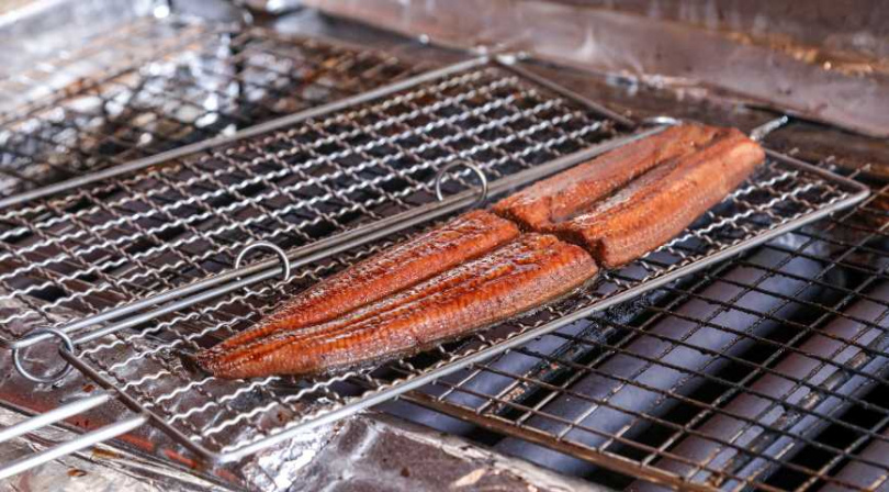 傳統串鰻燒烤需訓練較久，店家改以雙面烤網固定鰻魚取代傳統串鰻。（圖／趙文彬攝）