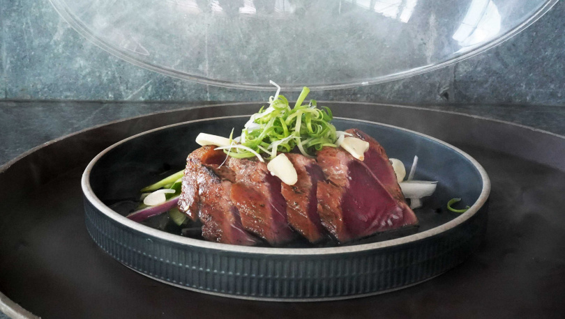 「鰹魚半敲燒」上桌前會以煙燻槍注入果木煙霧，掀蓋瞬間香氣撲面而來。（580元，圖／魏妤靜攝）