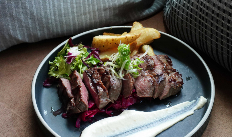 「直火燒烤厚切牛舌」頗具嚼勁，除了可蘸取地中海風味的大蒜蛋黃醬，搭佐炒過的紫高麗菜更酸香解膩。（880元，圖／魏妤靜攝）