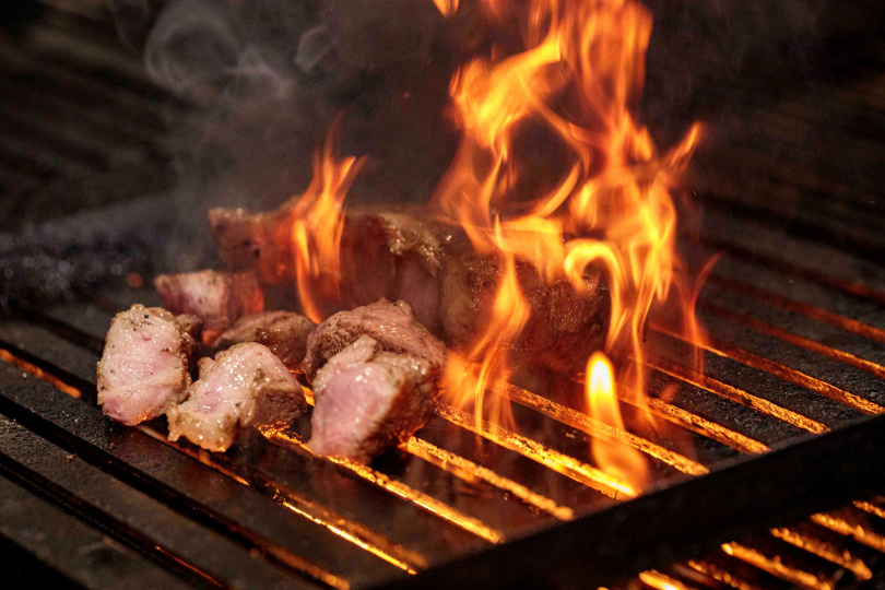 經過炭火洗禮的烤肉更添香氣，再剪成一塊塊適合入口的大小，包著生菜一起吃更是過癮。（圖／林士傑攝）