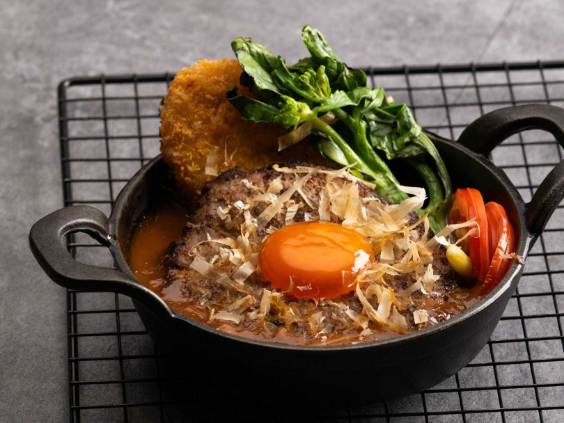 PAVO餐酒館的「八盎司照燒漢堡排」鋪上柴魚片與浸泡醬汁的雞蛋，再淋上照燒醬汁，風味多汁多層次。（280元＋10%，圖／漢來美食提供）