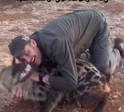 男子跟非洲鬣狗抱在一起。（圖／翻攝自臉書）