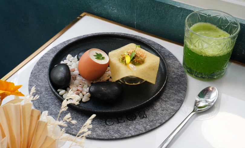 在品嘗首道開胃菜的柑橘班戟時，可先將滴管中的柑橘汁滴入，抓起餅皮四角一口咬下包覆雞胸肉、馬薩拉香料粉、焦化榛果等混合的內餡。（圖／魏妤靜攝）