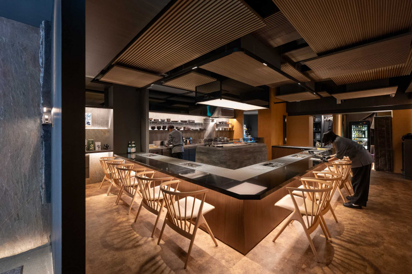 無論一樓用餐區（如圖）或VIP包廂都採板前設計，ㄇ字型的黑色吧檯嵌入了從日本進口的烤爐。（圖／焦正德攝）