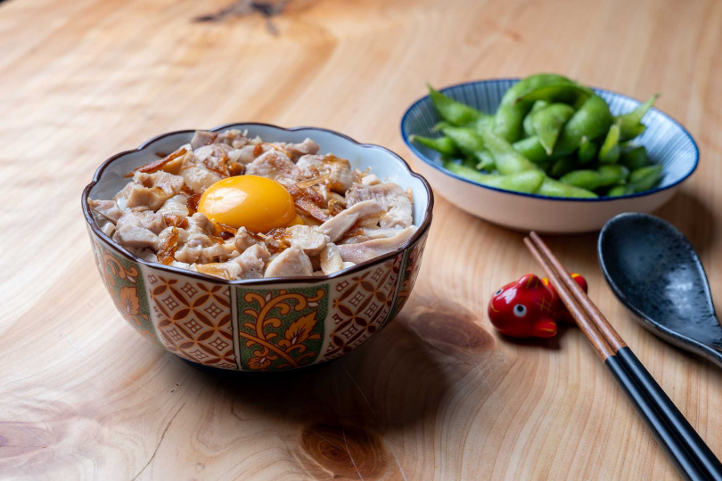 屬於台日混合的「嘉義月見雞肉飯」，使用在地錦龍醬油調製醬汁搭配生食級雞蛋，蛋液與醬汁、雞油融合更顯滑順。（100元，圖／焦正德攝）