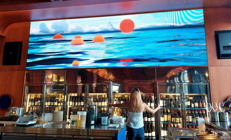 隨著酒櫃門開啟，酒櫃上方的銀幕畫面還會有橘紅氣泡漂出，既象徵酒液也好似港邊夕陽。