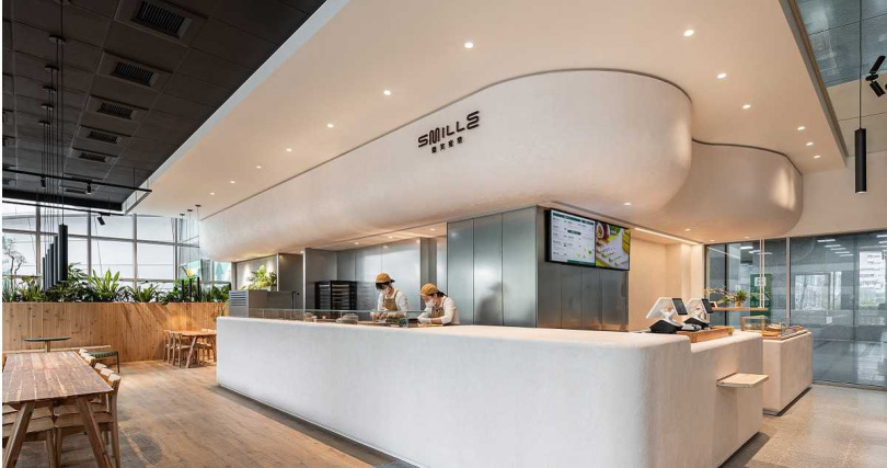 南港展覽館門市以植栽與明鏡打造出寧靜森林步道氛圍,若選擇外帶採臨櫃點餐,若選擇內用則有專門服務人員前來座位協助點餐。(圖/微笑蜜樂提供)