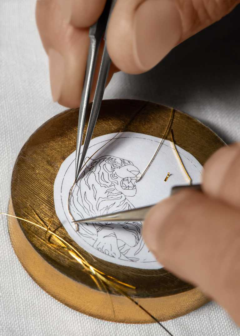 琺瑯工藝大師Anita Porchet先將設計圖複製到錶盤上，透過金絲線圍柵出虎肖圖騰。（圖╱PIAGET提供）