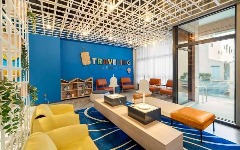 「福容徠旅澎湖」大廳配色以澎湖海域的藍，沙岸的灰白，玄武岩的黑，象徵夕陽的黃及活力的珊瑚紅作為主色調。（圖片提供／福容大飯店）