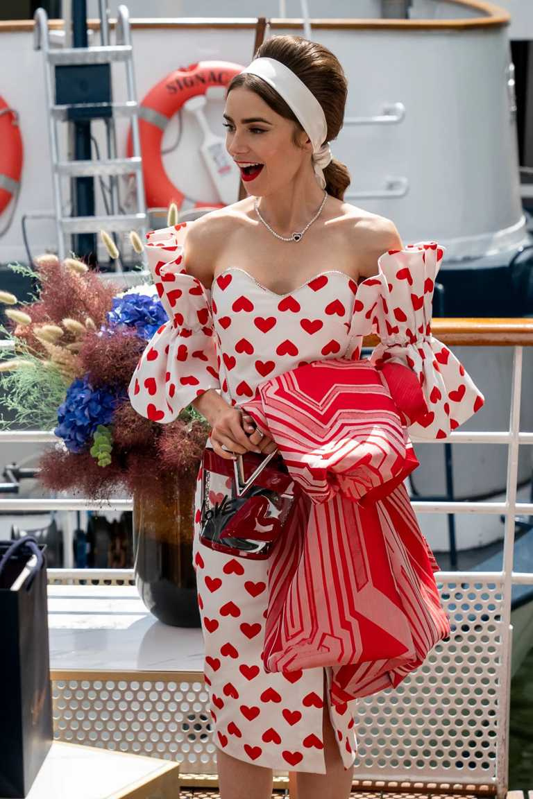 莉莉柯林斯一身心型圖案連身裙、紅色愛心手拿包，搭配法國頂級珠寶FRED「PrettyWoman」紅碧璽鑽石白金項鍊，展現浪漫甜美。（圖╱翻攝自網路）