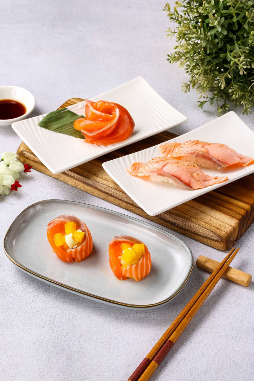 當季芒果碰撞肥美鮭魚！美威鮭魚夏日限定新品之一「鮮芒乳酪鮭魚球」（前），經典炙燒焦香的「火焰鮭魚握壽司」（中）與現切鮮美「鮭魚刺身」（後），交織出繽紛的盛夏鮭魚。（圖／品牌提供）