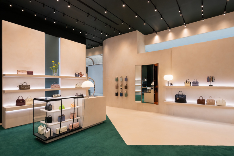 Valextra大巨蛋旗艦店以品牌綠與羊皮紙白打造義式空間，Museum Wall展示牆則呈現Iside系列特殊款式與工藝作品。（圖／品牌提供）