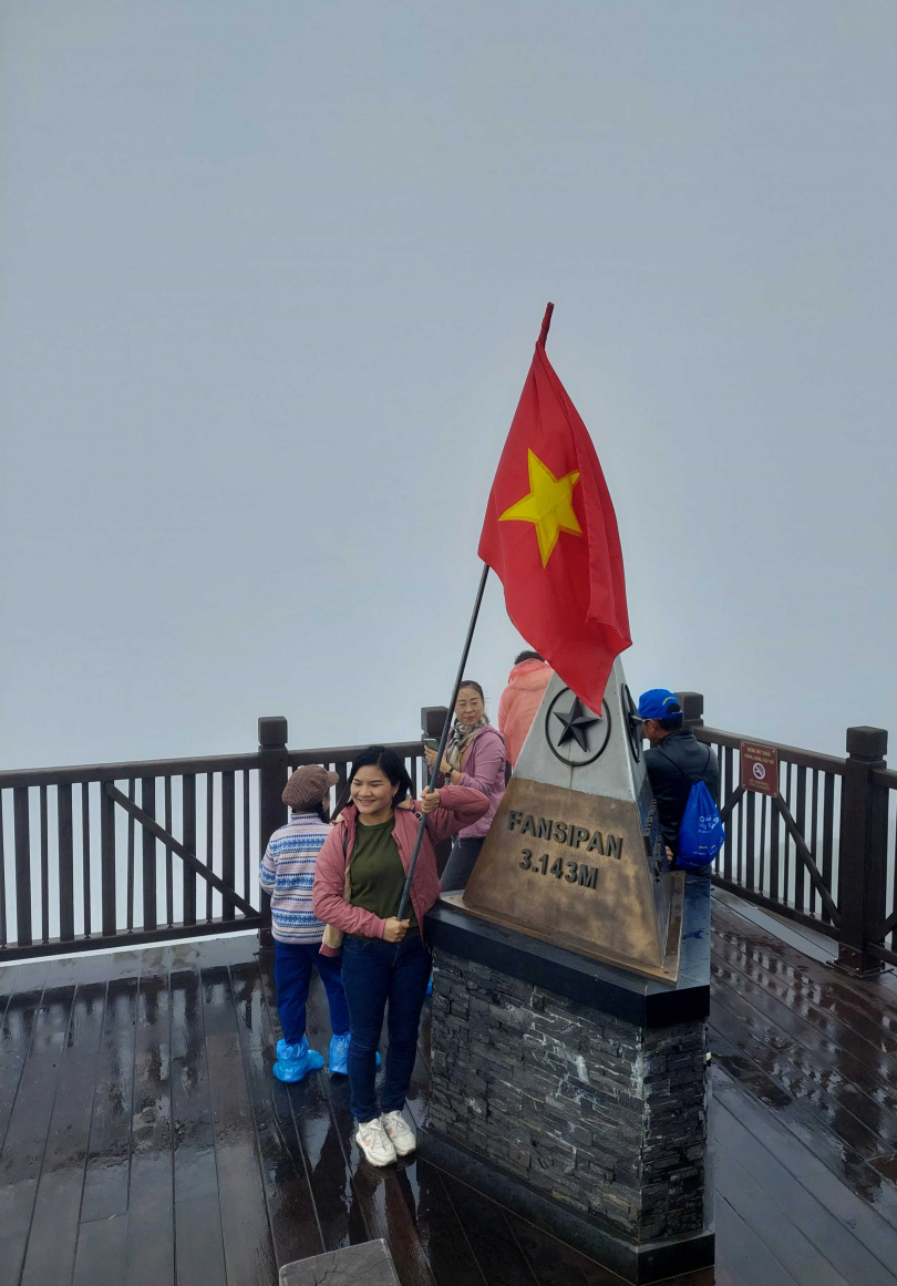 遊客拿起三角點現場放置的越南國旗作為拍照道具。（圖／魏妤靜攝）