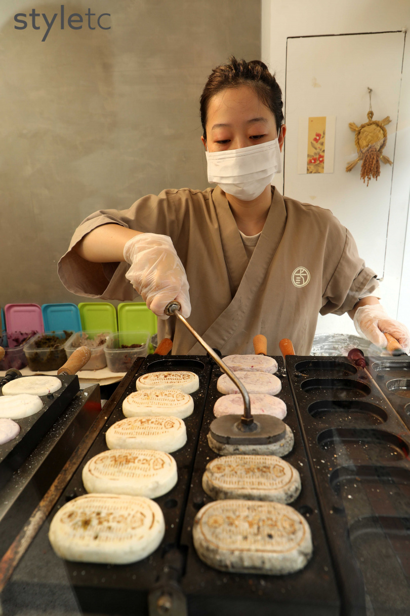 老闆娘澤木美里在以九州米製作的米餅上，壓印寫有店名的金幣圖案。（圖／于魯光攝）