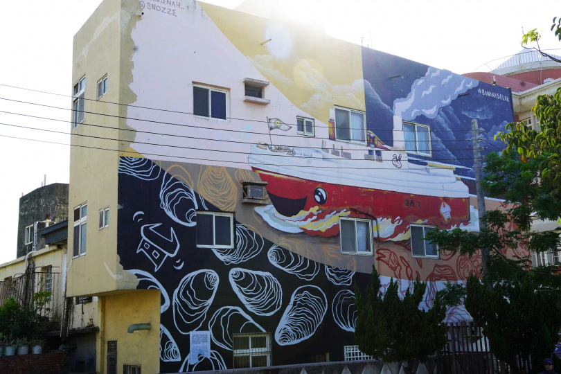 由馬來西亞藝術家Annienah與Snozze噴漆創作的3層樓高壁畫，船舶方向是從台灣海峽到陸地，暗喻為當地帶來更多財富。（圖／魏妤靜攝）