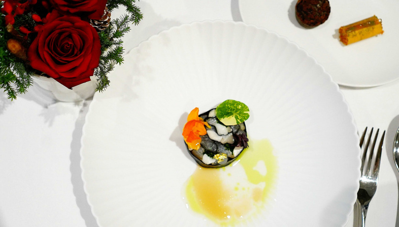以壽司卷呈現的冷前菜「馬賽克魚」，畫盤帶來魚兒悠游在水中的樣貌。