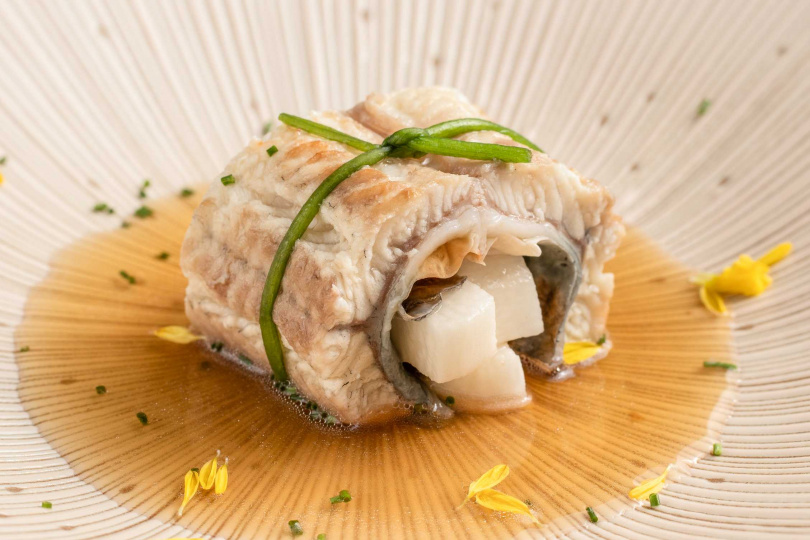 「鰻魚白樺蒸」先將白鰻烤到上色、再蒸到軟嫩，兩片白鰻魚肉夾入山藥，配上勾芡白柚子胡椒湯汁，整道菜精緻典雅，完整保留鰻魚的細緻美味。