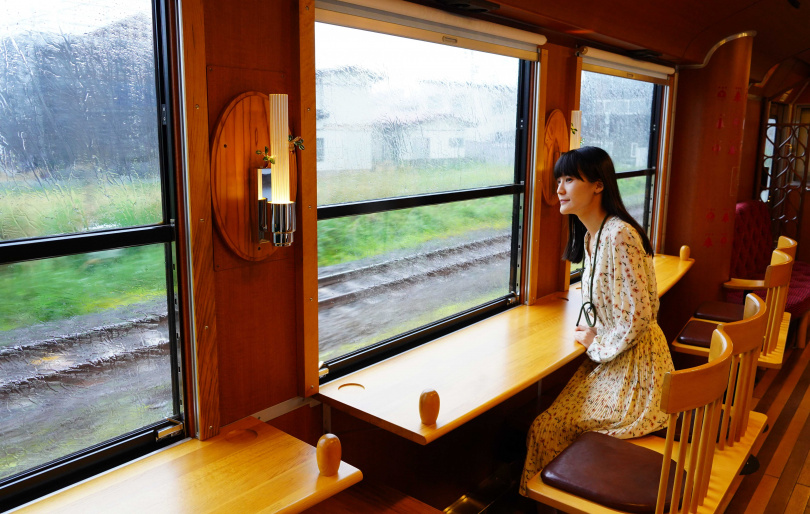 可以坐在玩具列車木椅上欣賞窗外的田野風光與遠處的鳥海山。（圖／魏妤靜攝）