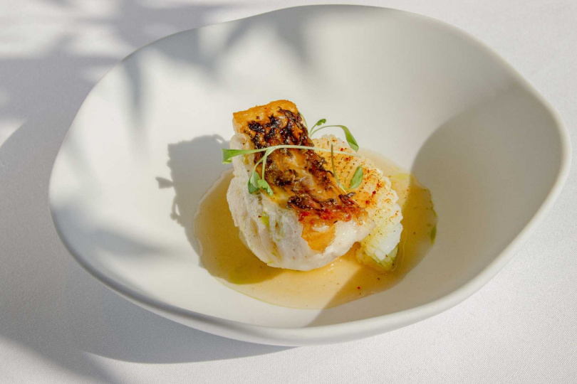 本季亮點熱前菜創意解構經典台式酒家菜魷魚螺肉蒜,轉化為「季節鮮魚佐魷魚螺肉蒜」,豬大骨高湯加入蝦米、陳年菜脯與螺肉罐頭等慢火熬煮並澄清濃縮,搭配香煎當令鮮魚,熟悉台味記憶以法式手法優雅升級層次,展現迷人的秋冬風味。(圖片提供/麗禧酒店)