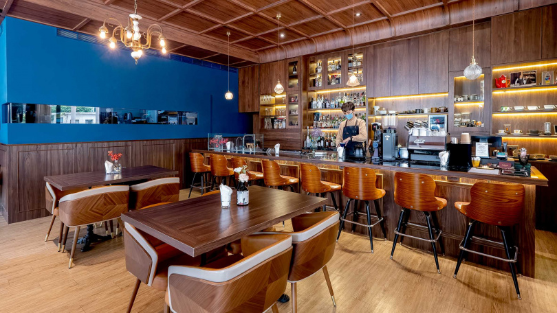 以午夜藍和大量木質調構築的空間帶出沉穩調性，90公分高的吧檯更可讓客人清楚看到Bartender與咖啡師的調製過程。（圖／焦正德攝)