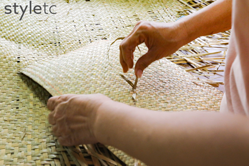 社區媽媽每日整理、編補藺草蓆，再結合皮革、布料等製作包款。（圖／林士傑攝）