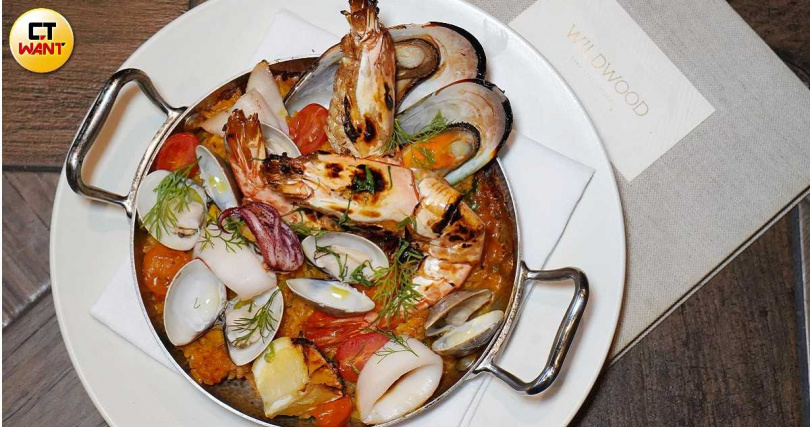 鋪上淡菜、透抽、明蝦、蛤蜊等澎湃海鮮的「托斯卡尼義式海鮮飯」（左，780元）、右為晚間套餐前菜「章魚、朝鮮薊、醃漬洋蔥、檸檬油醋」。（圖／魏妤靜攝）