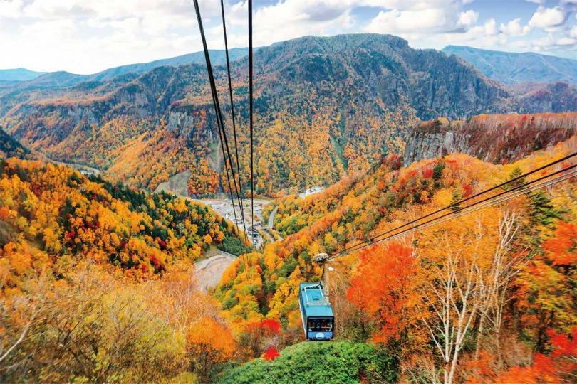 易飛網「北海道賞楓秋遊道東5日」，搭乘空中纜車俯瞰岩壁上繽紛的紅葉景緻。