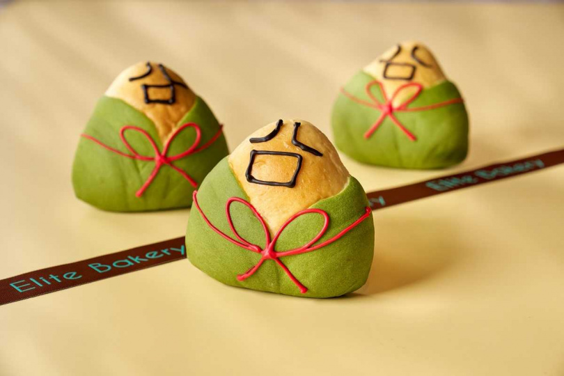 一禮烘焙推出的「抹茶紅豆麵包粽」以傳統日式紅豆麵包發想，麵包外型則設計成粽葉展開的可愛模樣，點綴擬真的冏字容顏，更具喜感。