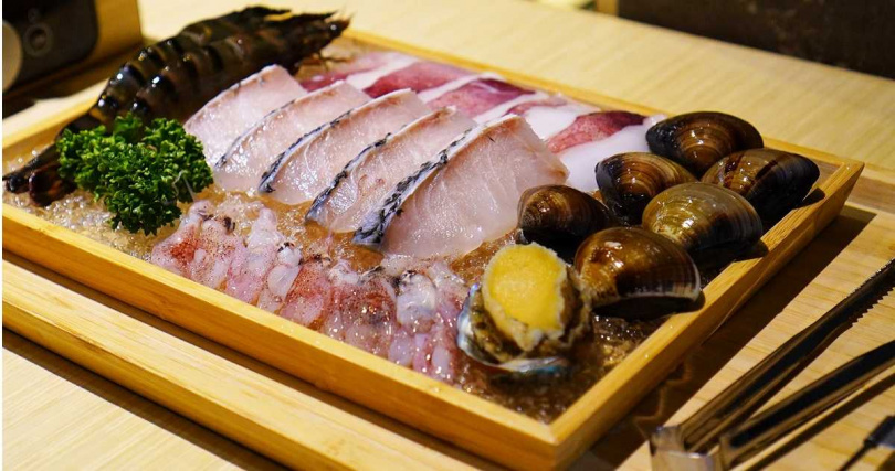 「草鱸盛合雙人海陸」的海鮮盤包括海草蝦、金目鱸、透抽、蛤蜊、螢光小捲與九孔鮑，另還會搭配肉片。（套餐價688元+10%／人）