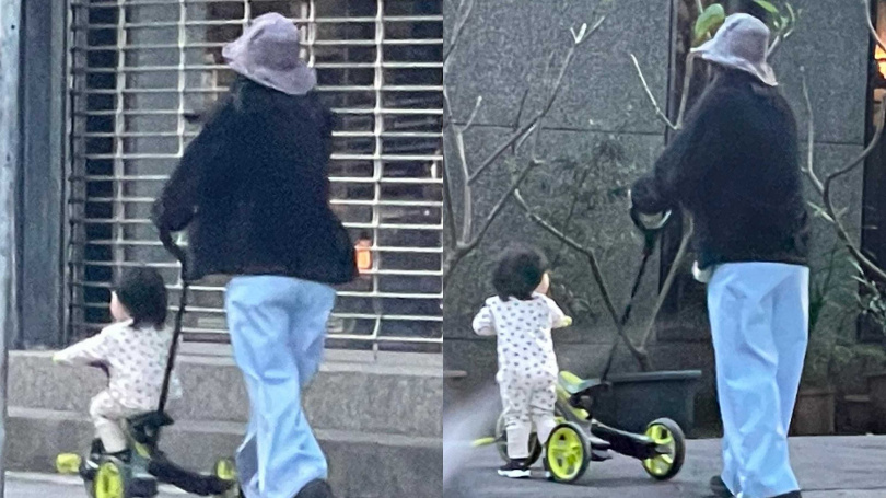 保姆推著兒子正在騎的三輪車，在台北市松山區附近溜搭。（圖／讀者提供）