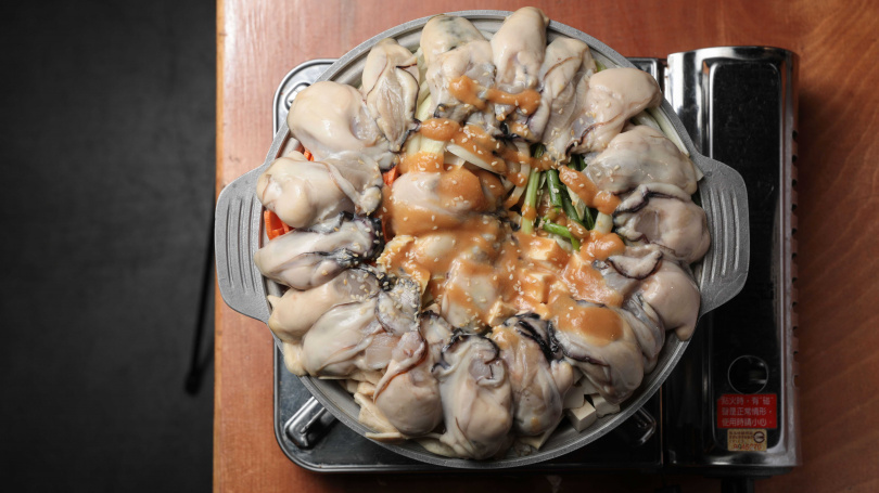幾乎要滿出鍋底的肥美牡蠣，上面又加上新鮮海膽，海味十足的大阪牡蠣鍋（980元），也是店內最受歡迎的菜色之一。（圖／林士傑攝）