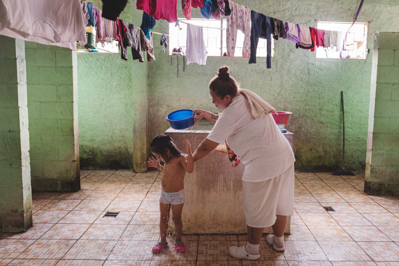 一名婦女在Granja Penitenciaria de Izalco的產婦囚區為她的孩子洗澡，這是薩爾瓦多整個監獄中唯一的產婦囚區，而她的兒子出生在監獄裡。（薩爾瓦多伊薩爾科，2021年3月）